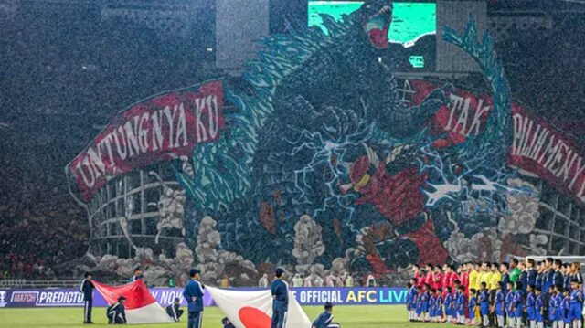 Koreografi raksasa dari suporter La Grande bergambar raksasa bergambarkan pertarungan antara Gundala dan Godzilla, serta tulisan "Untungnya Ku Tak Pilih Menyerah" di sisi kiri dan kanannya saat laga lanjutan putaran ketiga Grup C Kualifikasi Piala Dunia 2026 antara Timnas Indonesia melawan Jepang di Stadion Utama Gelora Bung Karno (SUGBK), Senayan, Jakarta, Jumat (15/11/2024). (Bola.com/Bagaskara Lazuardi)