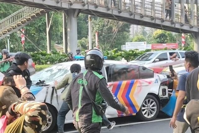 Sejumlah orang menghadang dan merusak kendaraan kepolisian yang baru saja keluar dari pintu gerbang Polda Metro Jaya di Jenderal Sudirman, Jakarta, Jumat (29/8/2025), sekitar pukul 15.15 WIB.(ACHMAD NASRUDIN YAHYA/KOMPAS.com)