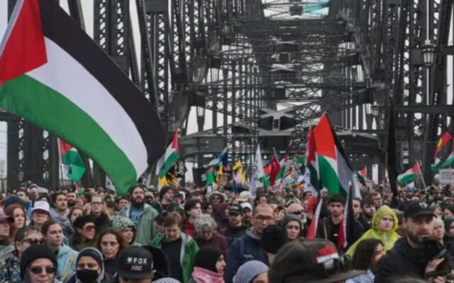 Para pengunjuk rasa pro-Palestina melintasi Jembatan Harbour di tengah cuaca Sydney yang basah dan dingin. (Sumber: Australian Associated Press/ Flavio Brancaleone)