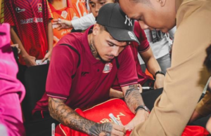 Debut Emosional Shayne Pattynama di Maluku: Misi Menang Persija Jakarta di Tanah Leluhur Shayne Pattynama menandatangani jersey milik Jakmania dalam acara meet & greet di Kantor Pusat Bank Jakarta pada Rabu (18/2/2025). (Bola.com/Nur Iman Ali)