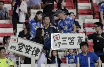 Budaya Disiplin Jepang Tuai Pujian, Fans Bersihkan Tribun Wembley Usai Taklukkan Inggris Pendukung Jepang mendukung tim mereka dengan tanda-tanda sebelum pertandingan sepak bola kualifikasi Asia Piala Dunia 2026 antara Bahrain dan Jepang di Stadion Nasional Bahrain di Manama pada 10 September 2024. (Mazen Mahdi / AFP)