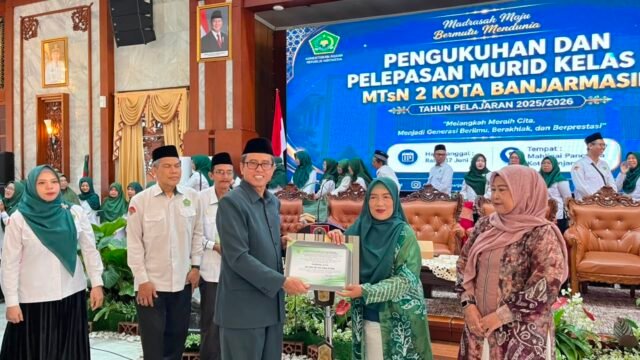 Kepala MTsN 2 Banjarmasin, Riduansyah, Serahkan Penghargaan kepada Guru Purna Tugas. Foto Dok Istimewa