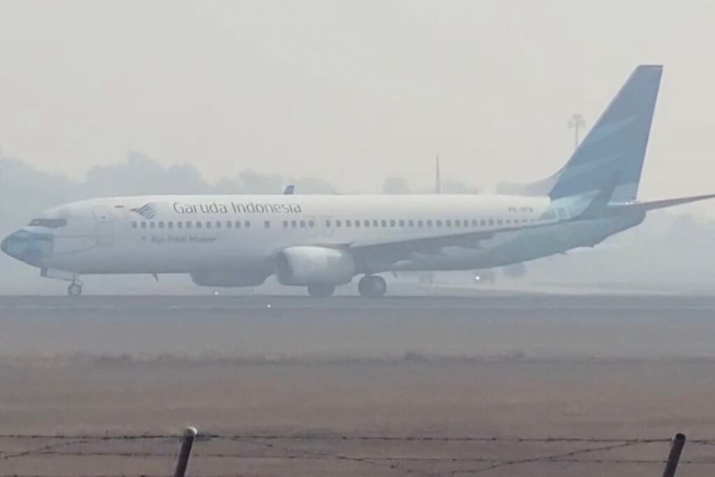 Pesawat Garuda bersiap take off di tengah kepulan kabut asap yang menyelimuti Bandara Syamsudin Noor Banjarbaru, Kalsel, Rabu (26/8/2026).(KOMPAS.com/ANDI MUHAMMAD HASWAR)