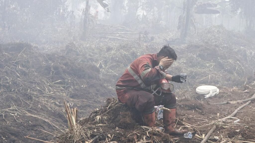 Personel Manggala Agni Daops Pekanbaru yang kelelahan membasuh muka dengan air saat berupaya melakukan pemadaman lahan yang terbakar di Desa Rimbo Panjang, Kecamatan Tambang, Kabupaten Kampar, Riau, Senin (24/8). Sebanyak 123 personel kepolisian diterjunkan untuk memperkuat operasi pemadaman dan pendinginan di kawasan Rimbo Panjang. Pendinginan menjadi salah satu tahapan penting setelah pemadaman untuk memastikan bara api tidak kembali muncul dan memicu kebakaran susulan. (ANTARA FOTO/Rony Muharrman)