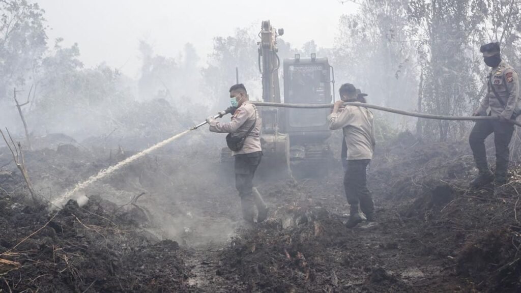 Anggota Brimob Polda Riau menyemprotkan air dalam upaya melakukan pemadaman lahan yang terbakar di Desa Rimbo Panjang, Kecamatan Tambang, Kabupaten Kampar, Riau, Senin (24/8). Pemerintah terus berupaya melakukan dan memastikan kebakaran hutan dan lahan dapat diatasi secara optimal dan cepat dengan memprioritaskan penanganan karhutla di enam provinsi yaitu Riau, Jambi, Sumatera Selatan, Kalimantan Selatan, Kalimantan Tengah dan Kalimantan Barat. (ANTARA FOTO/Rony Muharrman)