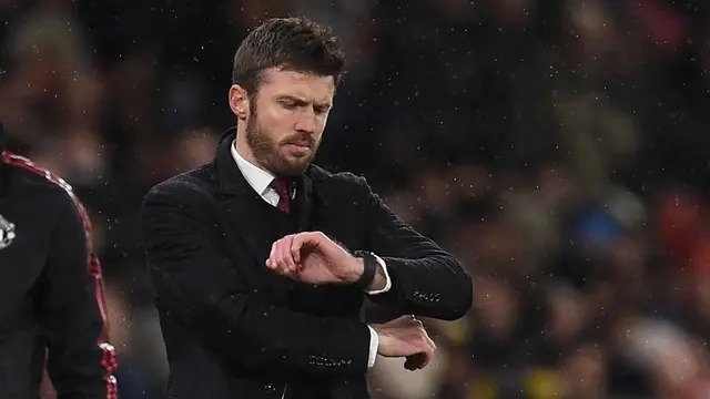 Hal itu disampaikan MU di laman resmi klub pada Rabu (14/1/2026) dini hari WIB. Tampak dalam foto, Michael Carrick saat masih menjadi pelatih sementara Manchester United melihat arlojinya selama pertandingan sepak bola Liga Premier Inggris melawan Arsenal di Old Trafford, Manchester, Inggris barat laut, pada 2 Desember 2021. (Oli SCARFF/AFP)